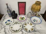de nombreuses assiettes et vases posés sur une table où se trouve un cadre photo