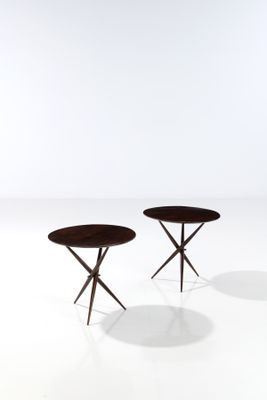 a pair of round tables with wooden legs on a white surface