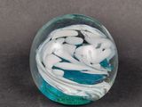 a glass ball with white and blue swirls on it