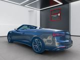the rear end of a blue convertible car in a showroom