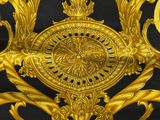 a gold clock on a black background with gold decorations