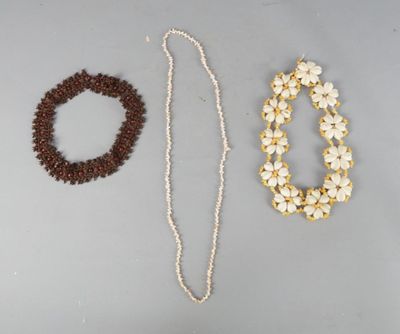 Deux colliers et un bracelet sont posés sur une table