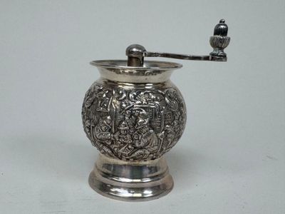 un moulin à café en argent surmonté d'un oiseau