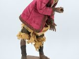 statue of a man in a pink coat on a wooden base