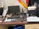 un bureau sur lequel se trouvent un ordinateur, une imprimante, une souris et d'autres objets