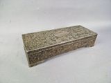 une vieille boîte en argent posée sur une table blanche