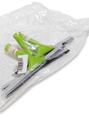 une paire de ciseaux dans un sac en plastique posé sur une surface blanche