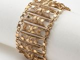 a close up of a gold bracelet on top of a napkin