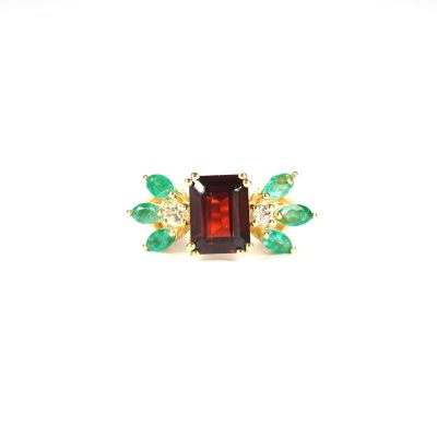 a close up of a ring with green and red stones