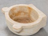 a stone bowl with a handle sitting on a table