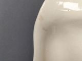 a close up of a white vase on a table