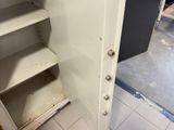 an open safe door in a room with a tile floor