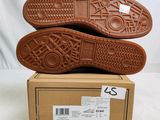 the soles of a pair of brown shoes are stacked on top of a box
