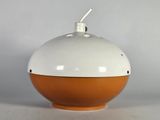 un petit objet orange et blanc posé sur une table blanche