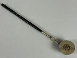 a small metal spoon with a handle on a white surface