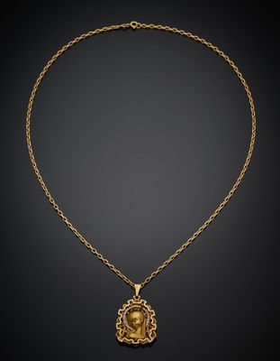 un collier en or avec une tête de lion suspendue à une chaîne