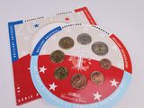 une assiette rouge, blanche et bleue sur laquelle sont posées des pièces de monnaie