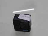 un petit appareil photo posé sur une table, sur lequel est collé un autocollant