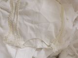 a picture of a baby in a white dress laying on a bed