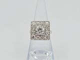 a diamond and white gold ring on a clear glass stand