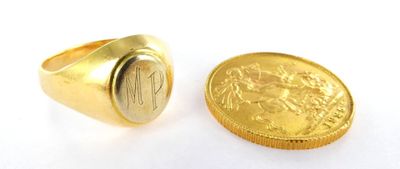 two gold rings with a coin in front of them on a white surface