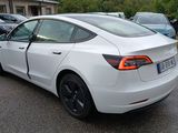 a white tesla model s parked in a parking lot