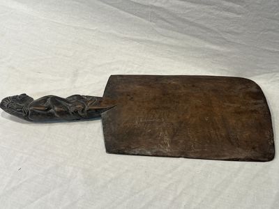 a wooden cutting board and a knife on a table