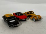 three toy cars sitting next to each other on a white surface