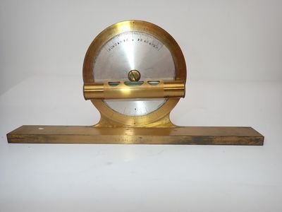 une horloge ancienne en laiton posée sur une étagère en bois, sur fond blanc