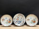trois assiettes ornées de motifs orientaux, posées sur une table