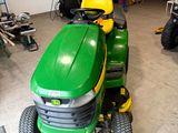 a green lawn mower parked in a garage