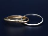 two wedding rings sitting on a black surface