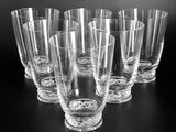 six glasses are lined up on a table with a black background