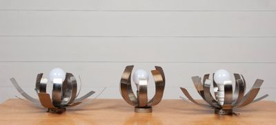 trois sculptures en métal posées sur une table en bois