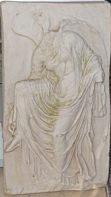 statue d'une femme assise sur un bloc de pierre, avec un oiseau sur l'épaule