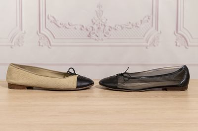 two pairs of black and beige shoes sitting on top of a wooden floor