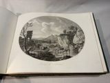 an open book with a picture of a landscape in it