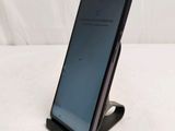 a close up of a cell phone on a stand on a white surface