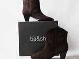 une paire de bottines en daim marron posée sur une boîte