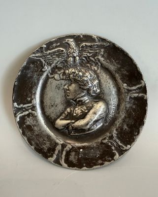 une assiette en argent sur laquelle est représentée une femme