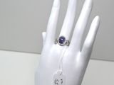 une main sur laquelle est passée une bague à laquelle est attachée une étiquette