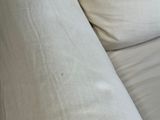 a cat that is sitting on a couch with pillows