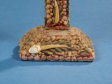 a figurine of a person holding a cross on a rock