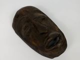 carved wooden mask on a white surface with a white background