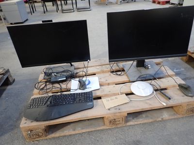 two monitors and a keyboard on a pallet in a warehouse