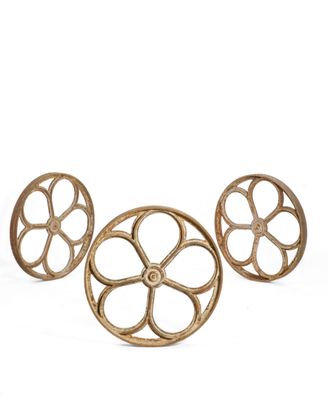 three antique cast iron wheels on a white background