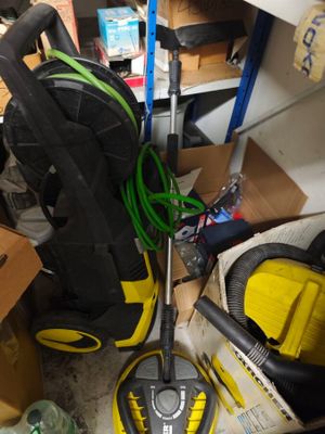 un aspirateur jaune et noir posé sur un sol encombré