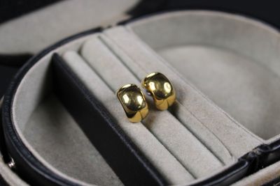 two gold rings in a case on a black surface