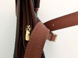 brown leather purse with zipper open on a white surface