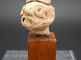 une image représentant une sculpture représentant une tête d'homme posée sur un bloc de bois